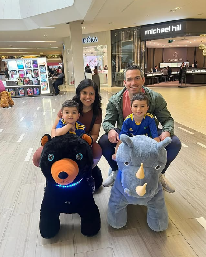 A family enjoying plush animal riders together inside a shopping mall