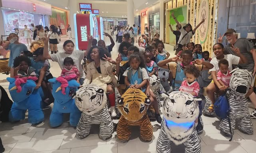 Families and friends gathered with plush animal riders