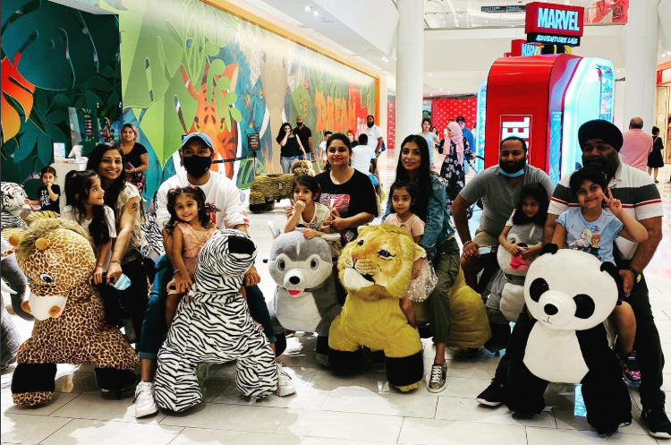 A large group of guests seated on a colourful variety of plush animal riders